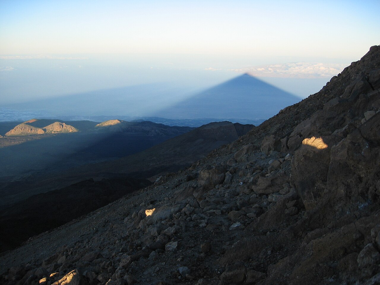 La sombra triangular del Teide al amanecer, vista desde cerca de la cumbre, extendiéndose sobre el Atlántico hacia La Gomera