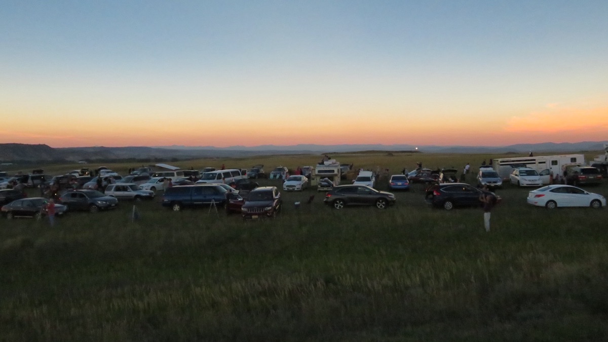 Midday twilight during the 2017 total eclipse at Orin Junction, Wyoming: the horizon glowing sunset-orange in every direction around a darkened prairie