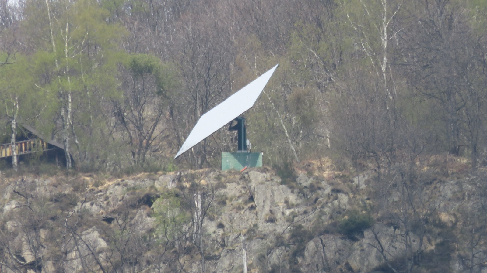 El espejo solar de acero de Viganella sobre su soporte en la ladera boscosa que domina el pueblo